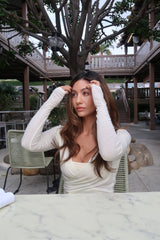 Woman outdoors wearing a cream INGE Sheer Wrap Top